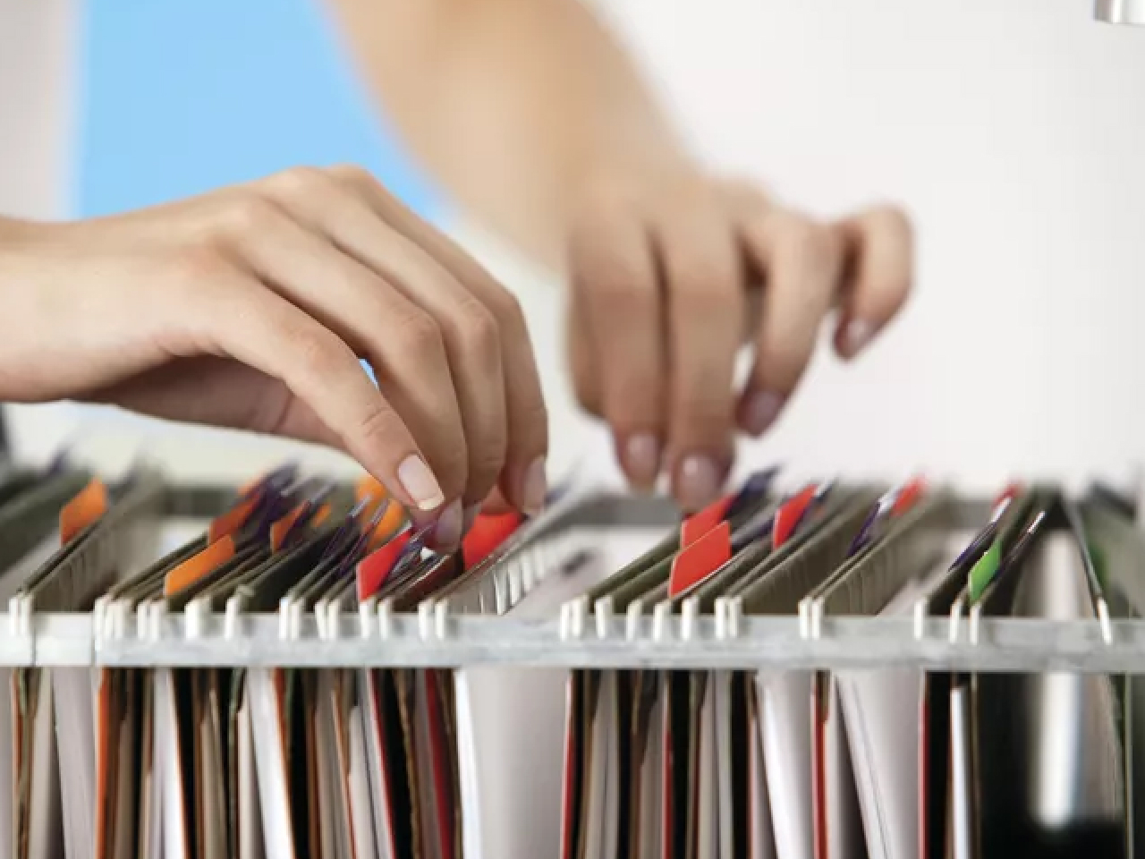 HR specialist reviewing employee personnel files and contracts